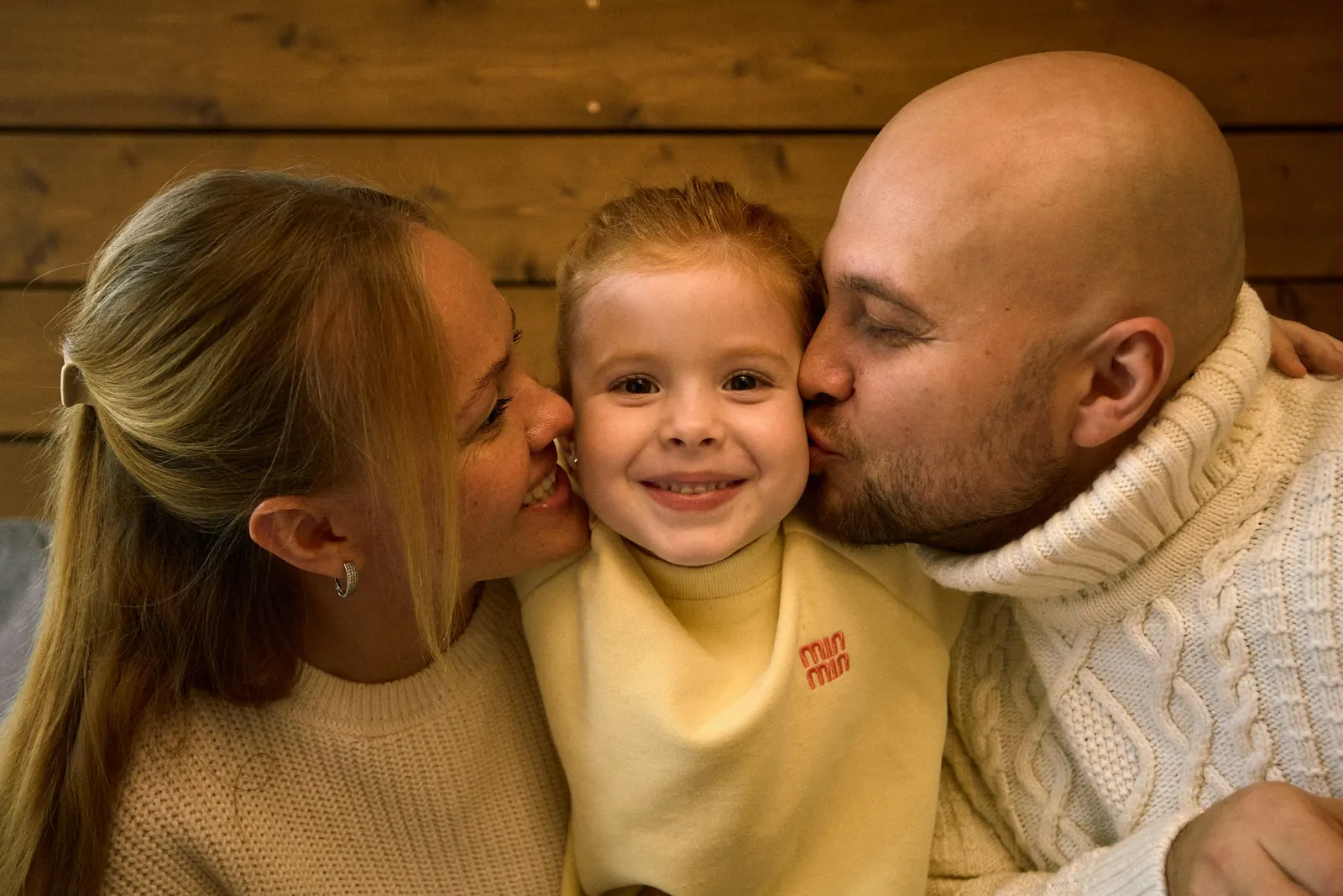 Родители обнимают дочку за новогодним столом